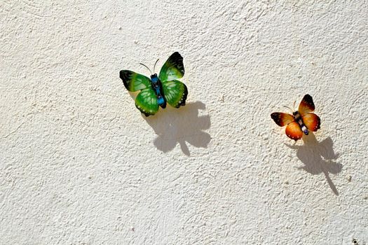 Two decorative butterflies on white wall of a house in Spain