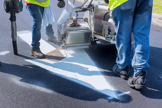 Road worker thermoplastic spray marking machine painting work on the street