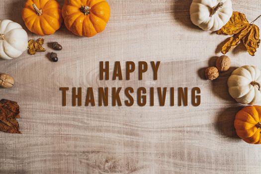 Happy Thanksgiving Day with pumpkin and nut on wooden table