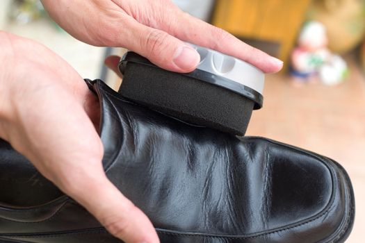 Hands polish leather black shoes.