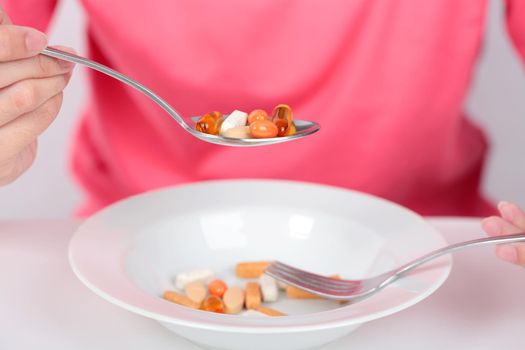 Young women eating medicine capsules on spoon for health.