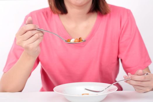 Young women eating medicine capsules on spoon for health.