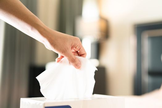 women hand picking napkin/tissue paper from the tissue box