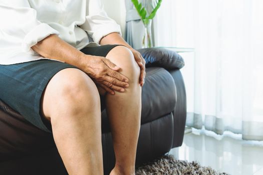 senior woman suffering from knee pain at home, health problem concept
