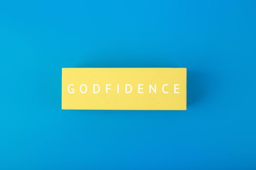 Godfidence single word on yellow rectangle against bright blue background. Modern biblical creative religious concept of faith