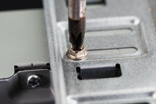 screwdriver that unscrews a screw of a pc on the hard disk side