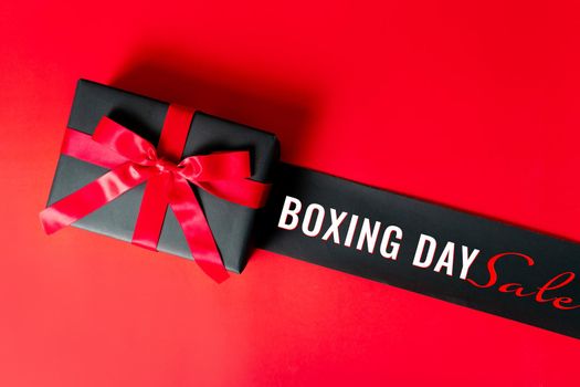 Boxing day Sale concept Christmas gift box on red background, top view