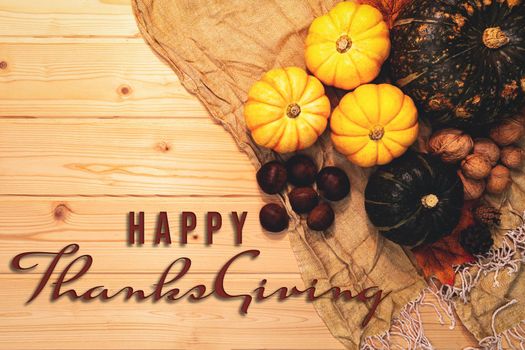 Happy Thanksgiving Day with pumpkin and nut on wooden background