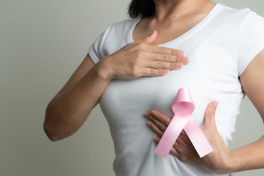 pink badge ribbon on woman chest to support breast cancer cause. breast cancer awareness concept