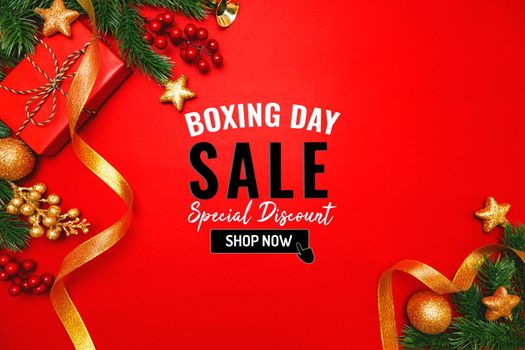 Boxing day sale with Christmas present and xmas decoration on red background