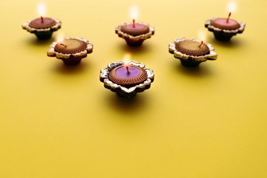 Happy Diwali - Clay Diya lamps lit during Dipavali, Hindu festival of lights celebration. Colorful traditional oil lamp diya