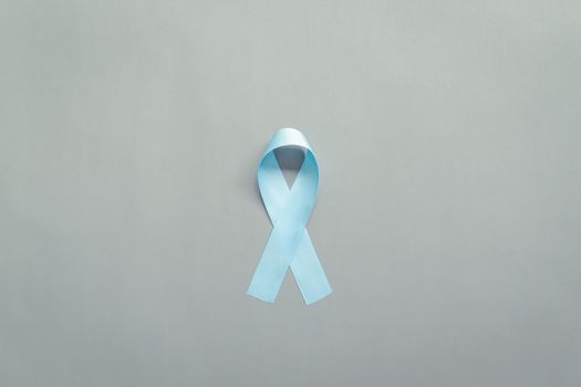 November light blue ribbon on gray background with copy space, Prostate cancer awareness month, men's health concept