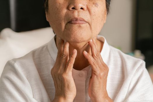 Senior adult women touching the neck feeling unwell coughing with sore throat pain.Healthcare and medicine concept