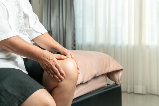 senior woman suffering from knee pain at home, health problem concept