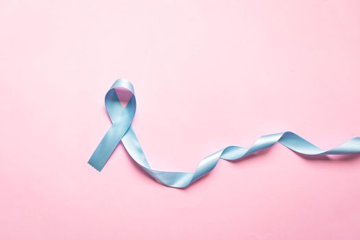 November light blue ribbon on pink background with copy space, Prostate cancer awareness month, men's health concept