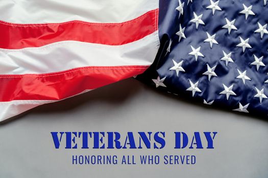 Veterans day. Honoring all who served. American flag on gray background with copy space.