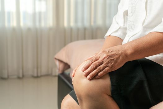 senior woman suffering from knee pain at home, health problem concept