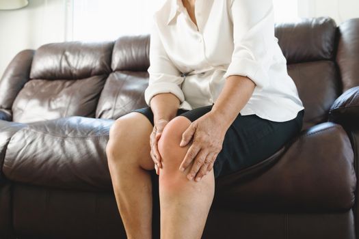 senior woman suffering from knee pain at home, health problem concept