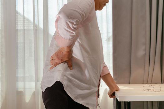 Old woman back pain at home, health problem concept