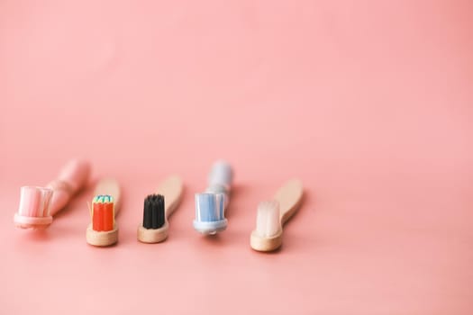 colorful toothbrushes on pink background with copy space ,