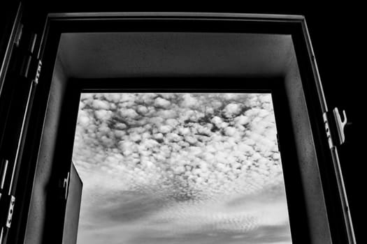 Altocumulus floccus sky through the window. Monochrome picture.