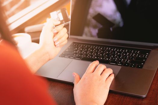 Woman hands holding credit card and using laptop. Online shopping