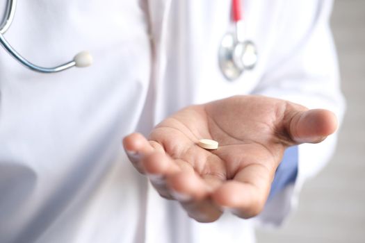 doctor holding medical pill on palm of hand .