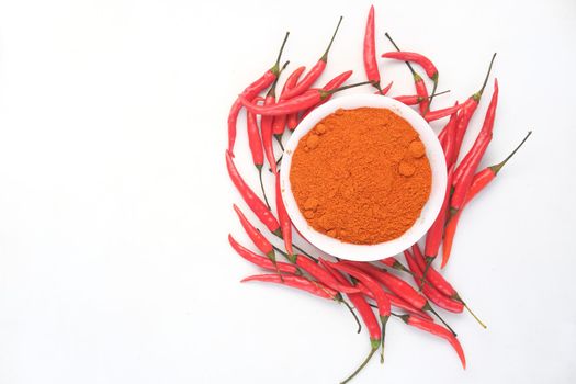 Chili powder and dried peppers on table background.