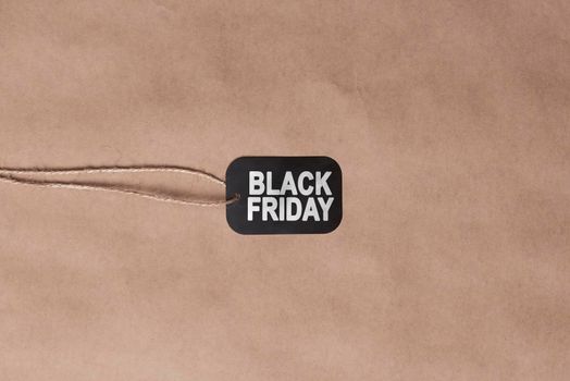 Black friday concept. Sale shopping tag on craft background