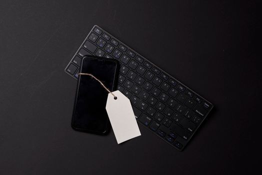 Black friday concept with mobile phone and keyboard on black