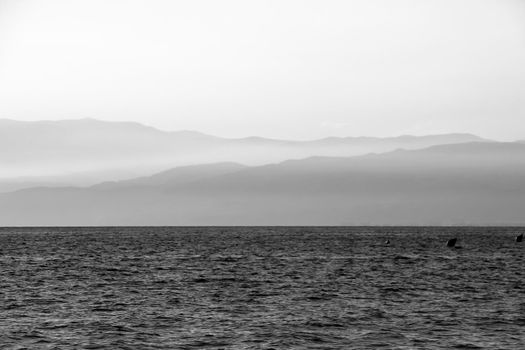 Afternoon on the Salinas beach in Cabo de Gata, Almeria, Spain. Foggy Mountains in the background. Monochrome picture.