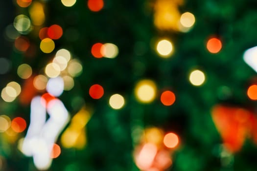 Blurred image of festive Christmas tree with decorations. Defocused christmas background. Merry Christmas background. Closeup shot of Christmas tree with Xmas decorations