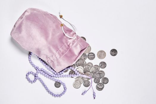 Concept of islamic finance on white background. Sharia-compliant finance - banking or financing activity. Coins and praying beads. Zakat, islamic banking
