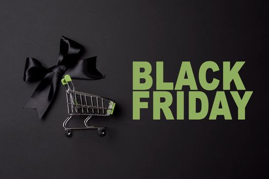 Black friday concept with shopping trolley on black background
