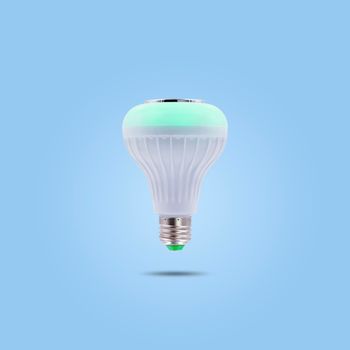 Green color LED energy saving lamp 230v isolated on blue pastel color background.