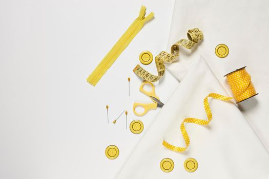 Sewing items from above. Flat lay composition with sewing accessories on light color background. Items for sewing, Sewing clothes, measuring tape, tailoring scissors, threads, buttons and needles