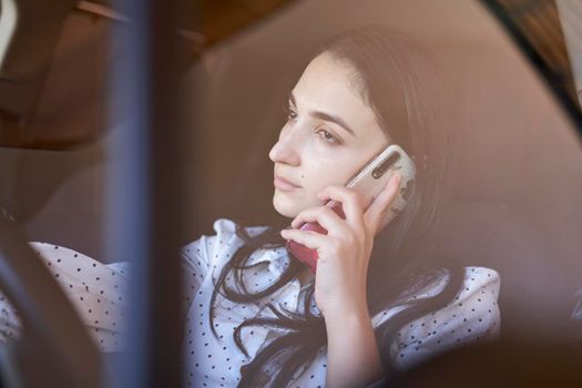 Unsafe driving. Young multiracial woman talking on the phone while driving. Distracted Driving. Female driving and talking on cellphone