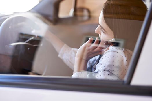 Unsafe driving. Young multiracial woman talking on the phone while driving. Distracted Driving. Female driving and talking on cellphone