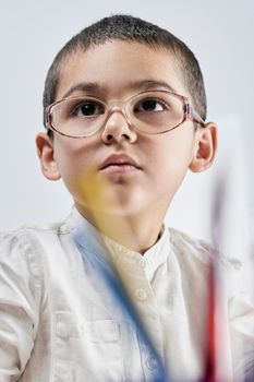 Vertical portrait of a cute smart boy in glasses