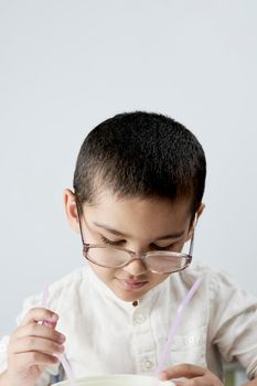 A little nerd kid in big glasses busy with chemical experiments against the white background