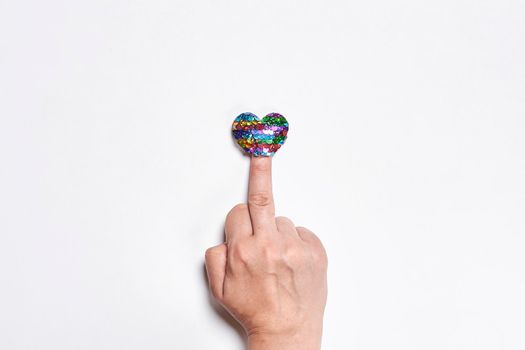 Fuck love. Middle finger and heart shape balloon. Hand of person showing fuck handgesture over white backgrounbd