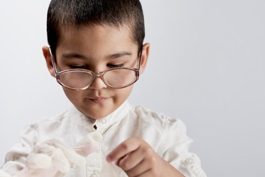 Little boy scientist in a lab coat and eyeglasses against the white background