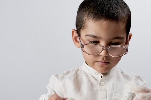 A smart mixed raced boy wearing glasses against the white background