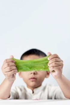Vertical shot of a kid who loves playing with slime