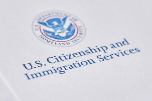 Tashkent, Uzbekistan - 13 August, 2021: United States Citizenship and Immigration Services. Envelopes with letter from USCIS on United States flag from Department of Homeland Security