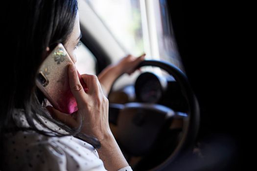 Unsafe driving. Young multiracial woman talking on the phone while driving. Distracted Driving. Female driving and talking on cellphone