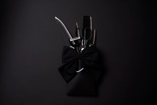 Black Friday concept. A kitchen set of black knifes on black background. Sharp knifes, kitchen slicer and scissors in the shopping bag packaged and bowed with ribbon