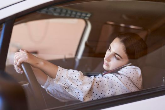 Unsafe driving. Young multiracial woman talking on the phone while driving. Distracted Driving. Female driving and talking on cellphone