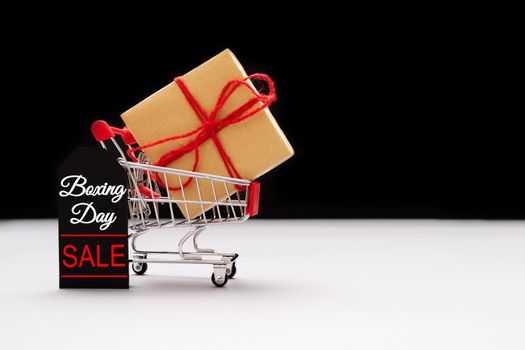 Boxing day sale, shopping cart and gift box with price tag