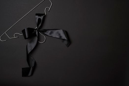Black friday concept. Steel Cloth Hanger with black ribbon on dark background